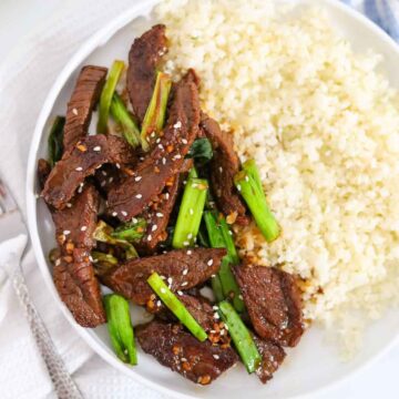 overhead shot of serving of keto mongolian beef on a white plate.