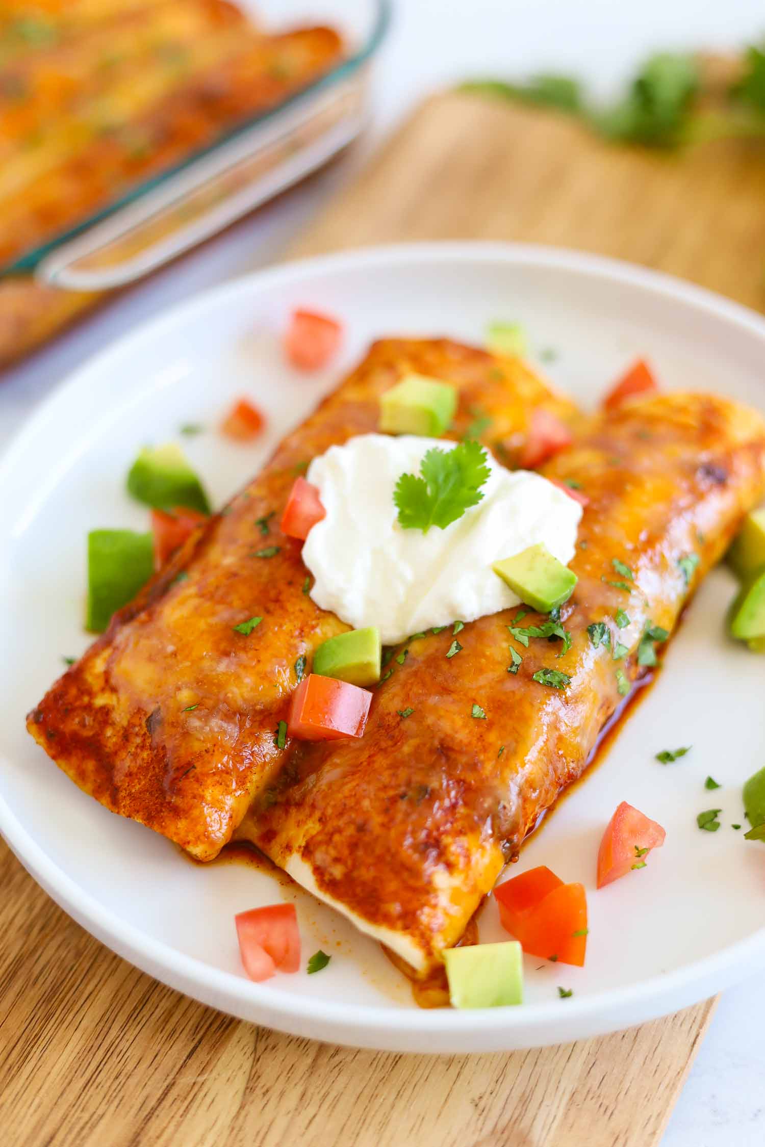 red chicken enchiladas with cheese on a plate 