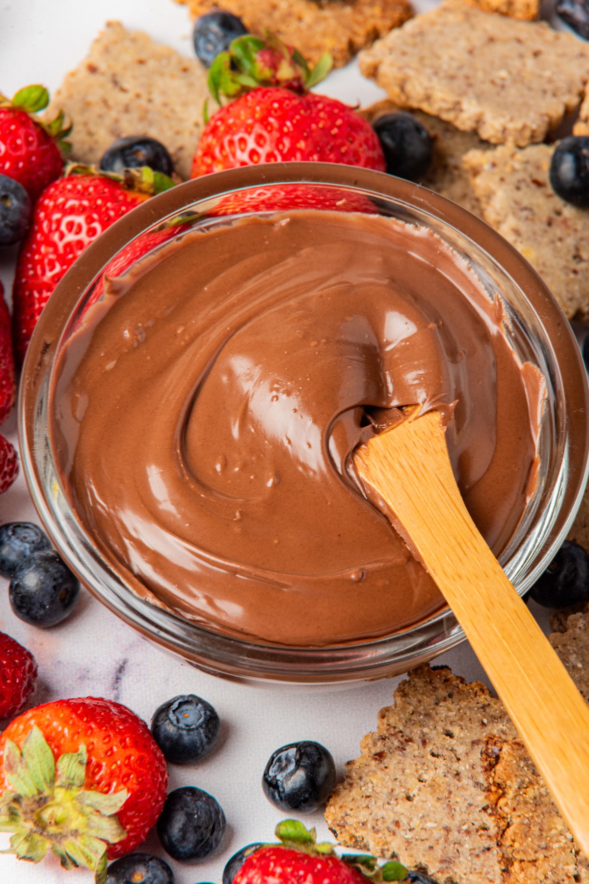 sugar free nutella in a bowl with berries and keto crackers 