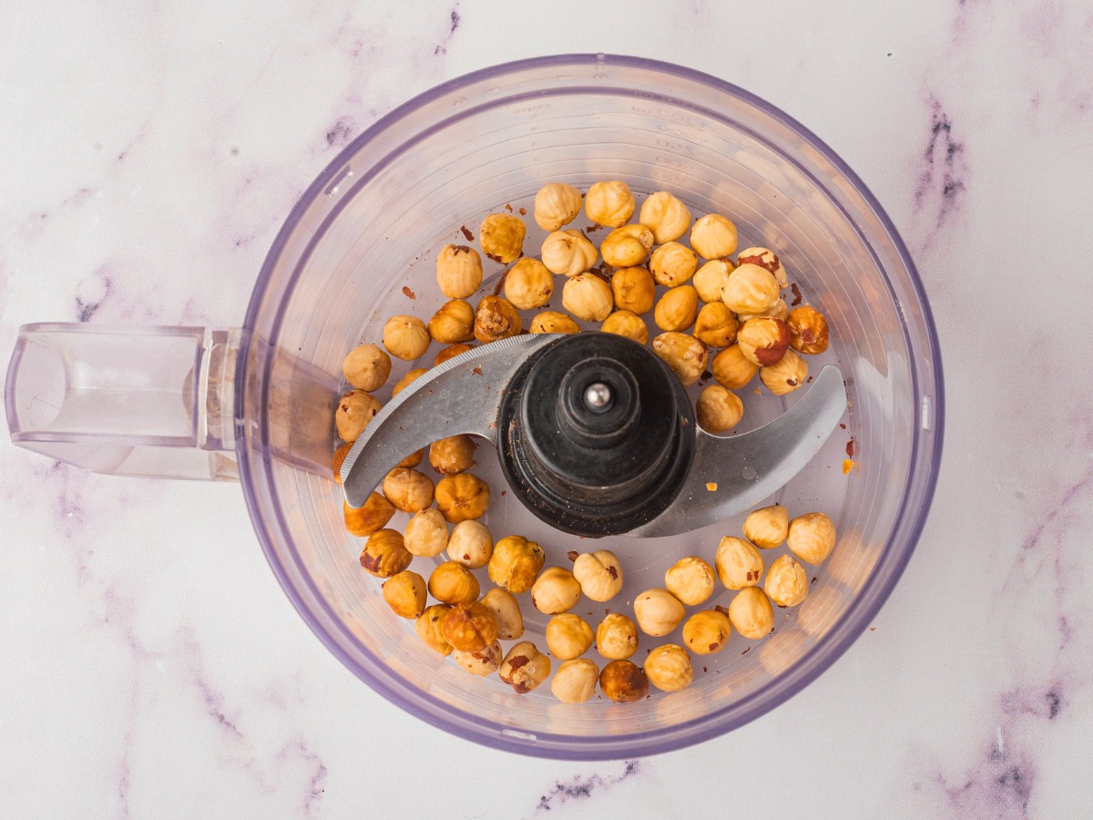 adding roasted hazelnuts to processors