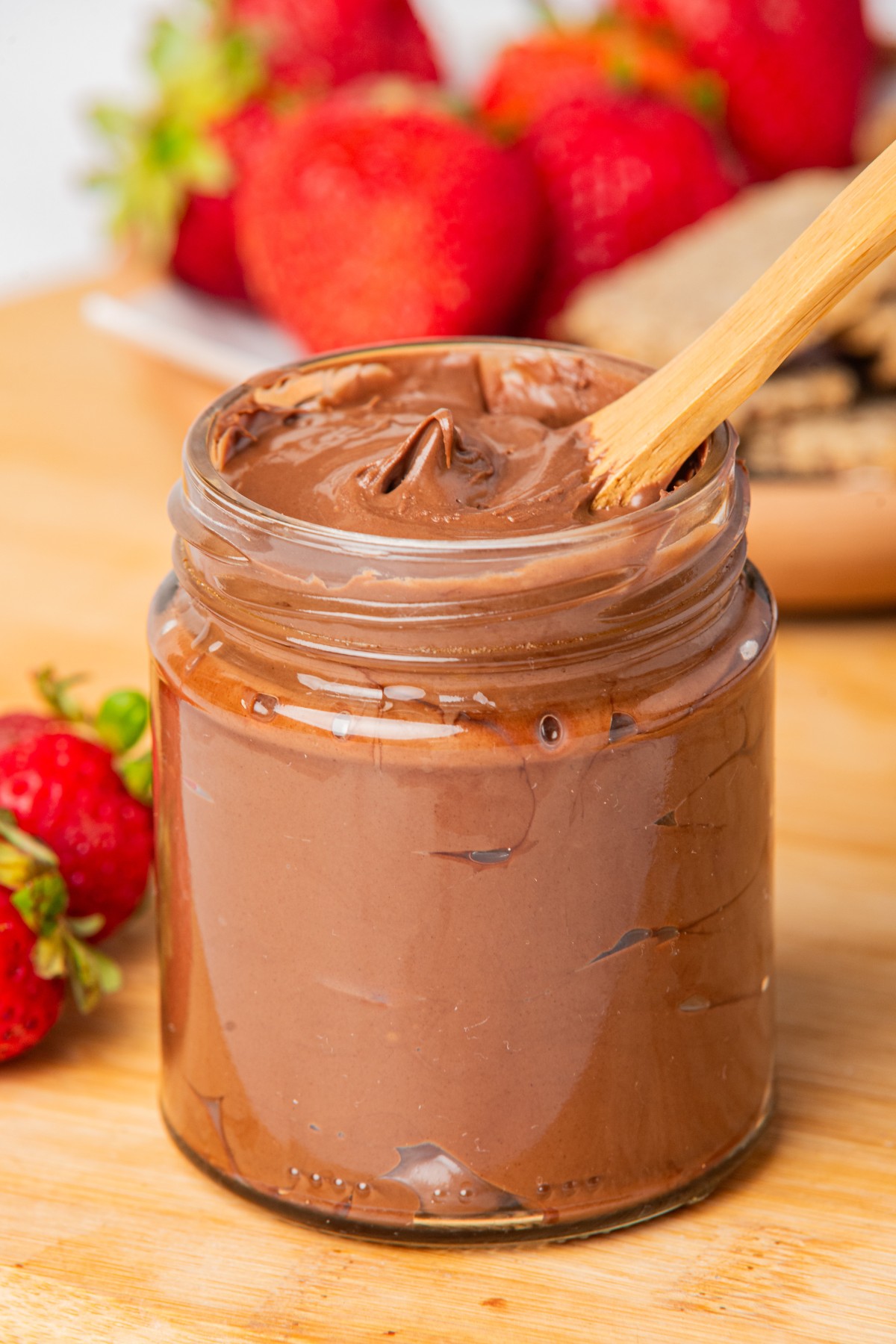 keto nutella chocolate in a glass jar with a window spoon 