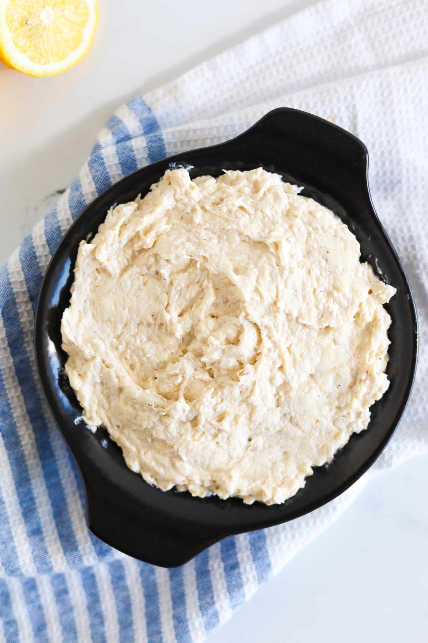 adding crab dip to a small cast iron skillet 