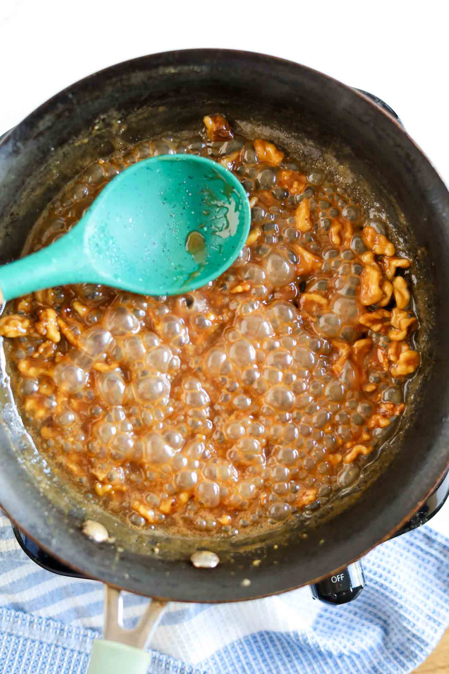 stirring honey walnut sauce to pour over crispy shrimp 