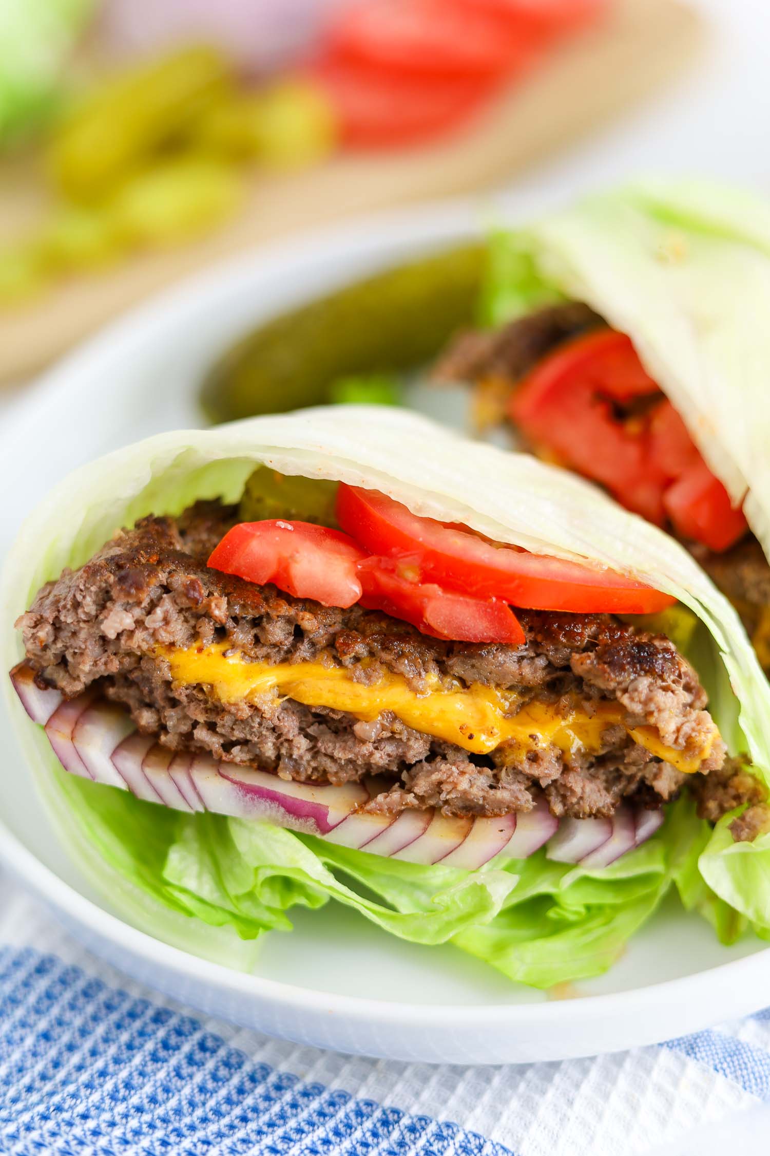 lettuce wrapped juicy lucy with veggies on a white plate 