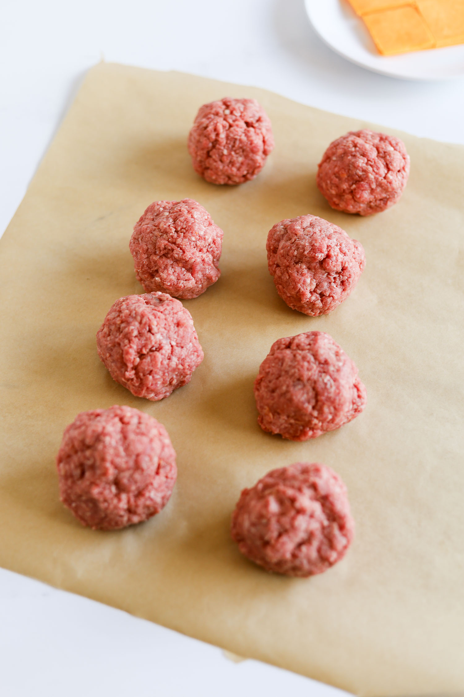 rolled up ground beef on parchment paper 