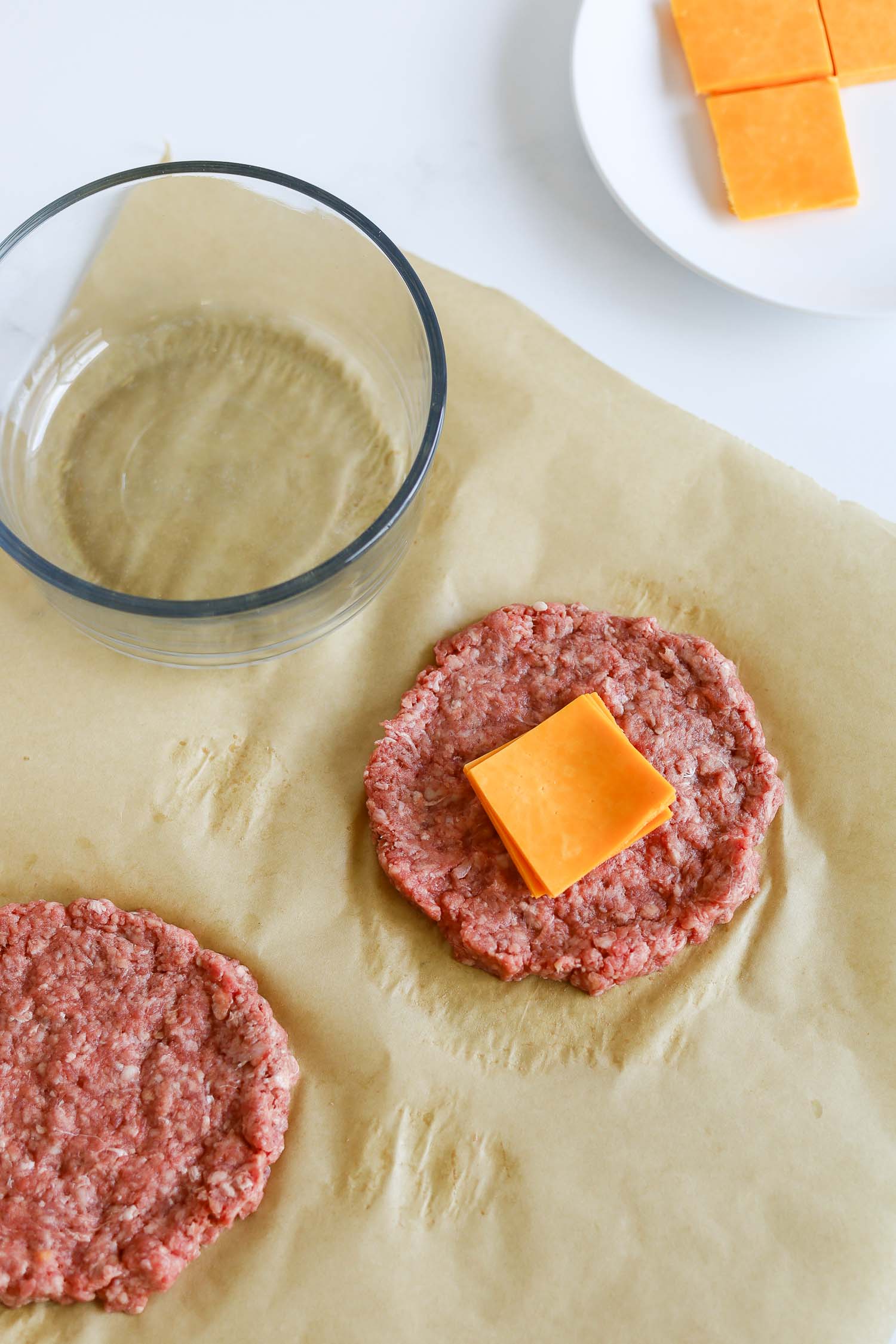 adding slice of cheese in between burger patties 