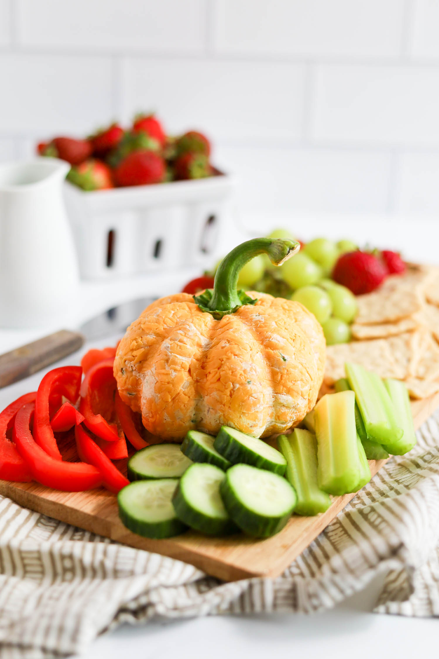 cheese ball on a wooden board with fruit and crackers 