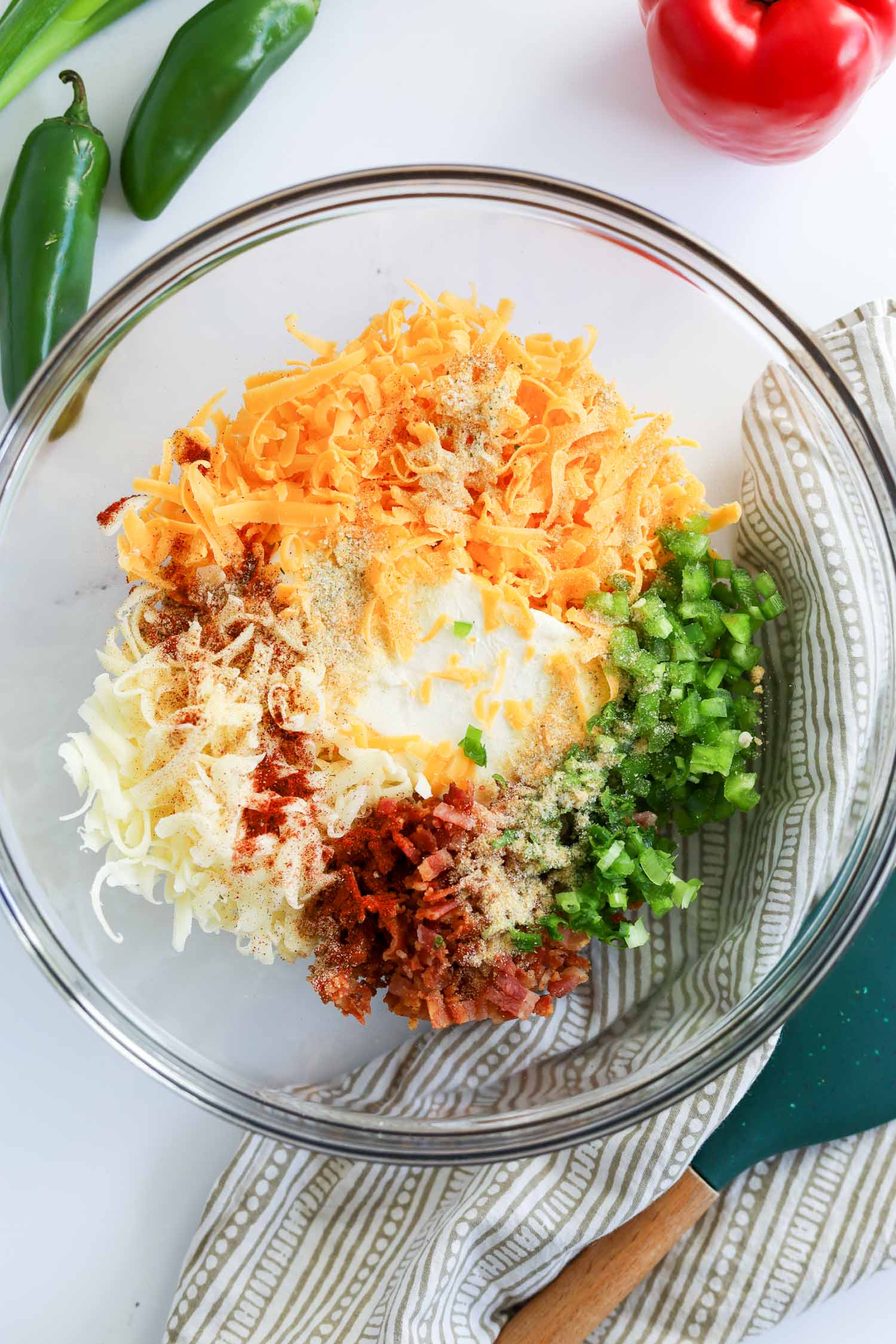 adding all of the cheese ball ingredients into a glass bowl 