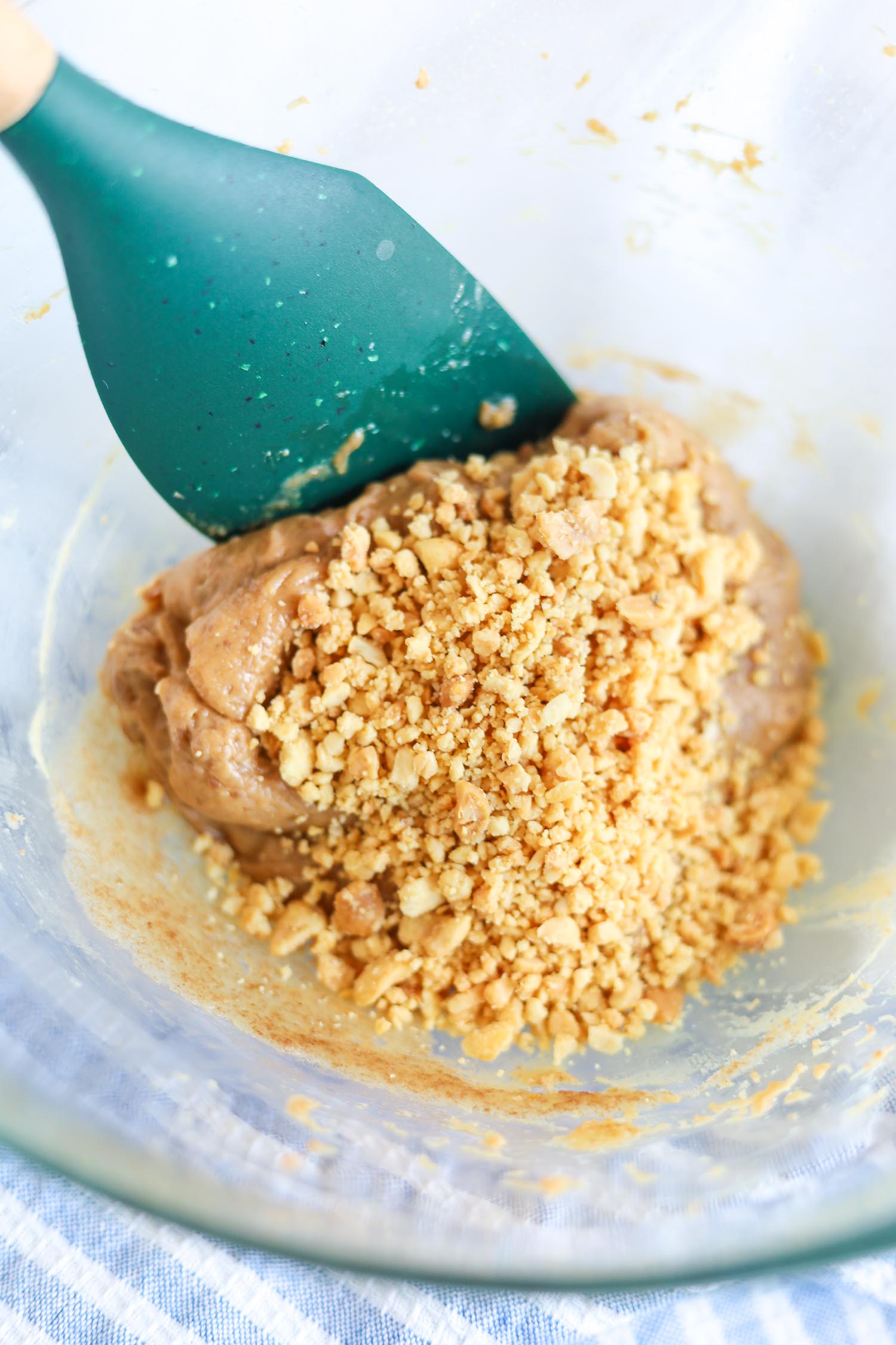 adding chopped peanuts to peanut butter caramel layer 