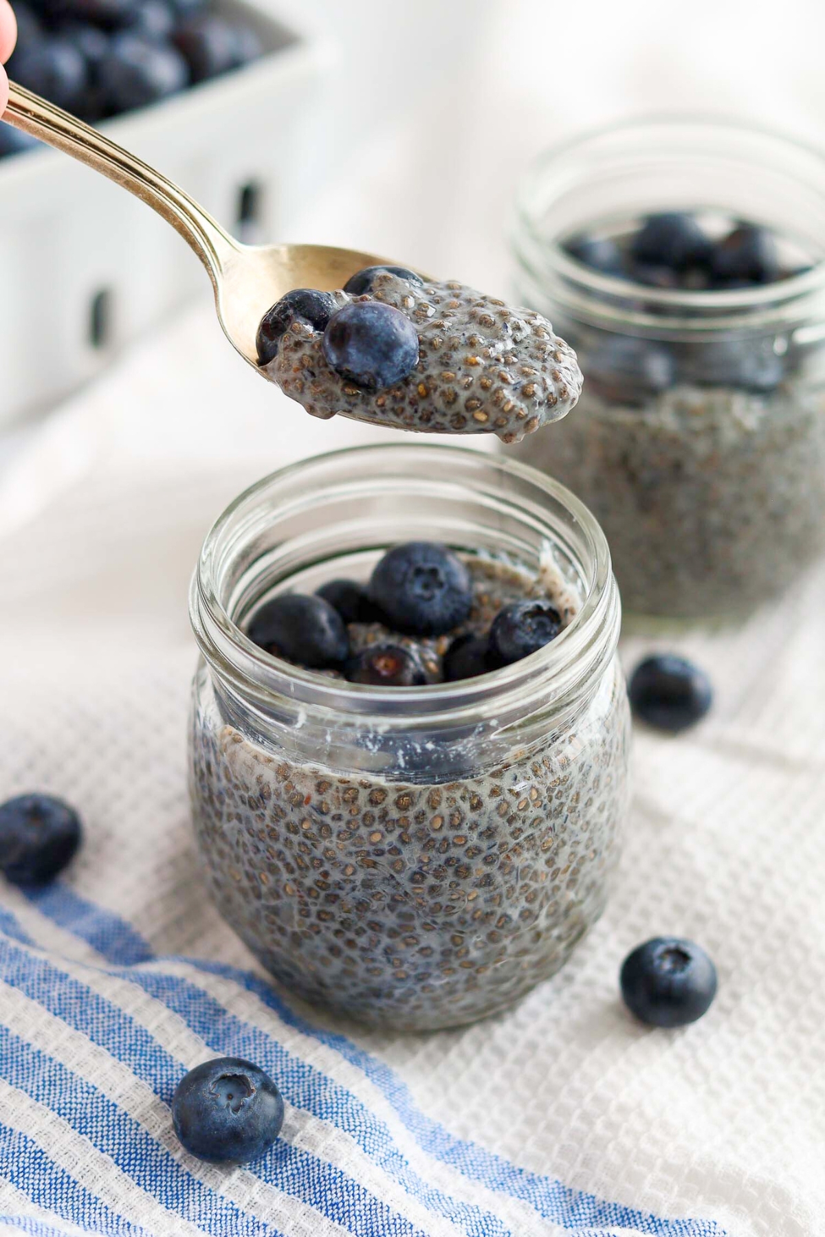 eating a spoonful of chia seeds with fresh blueberries