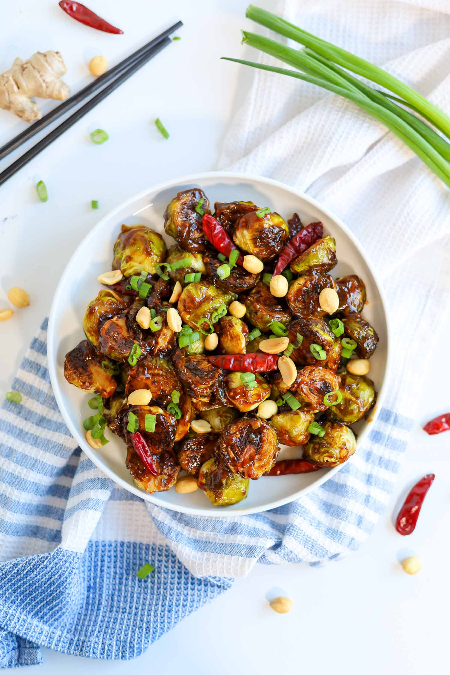 overhead shot of kung pao brussel sprouts in a white bowl 