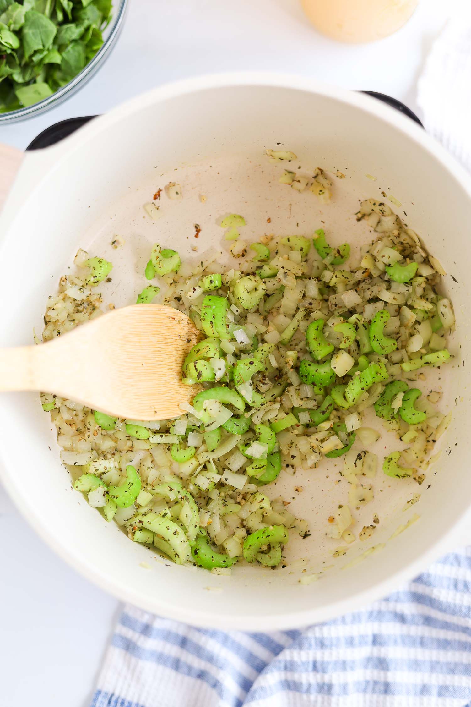 adding chopped celery, onion and garlic in a hot pot and saute