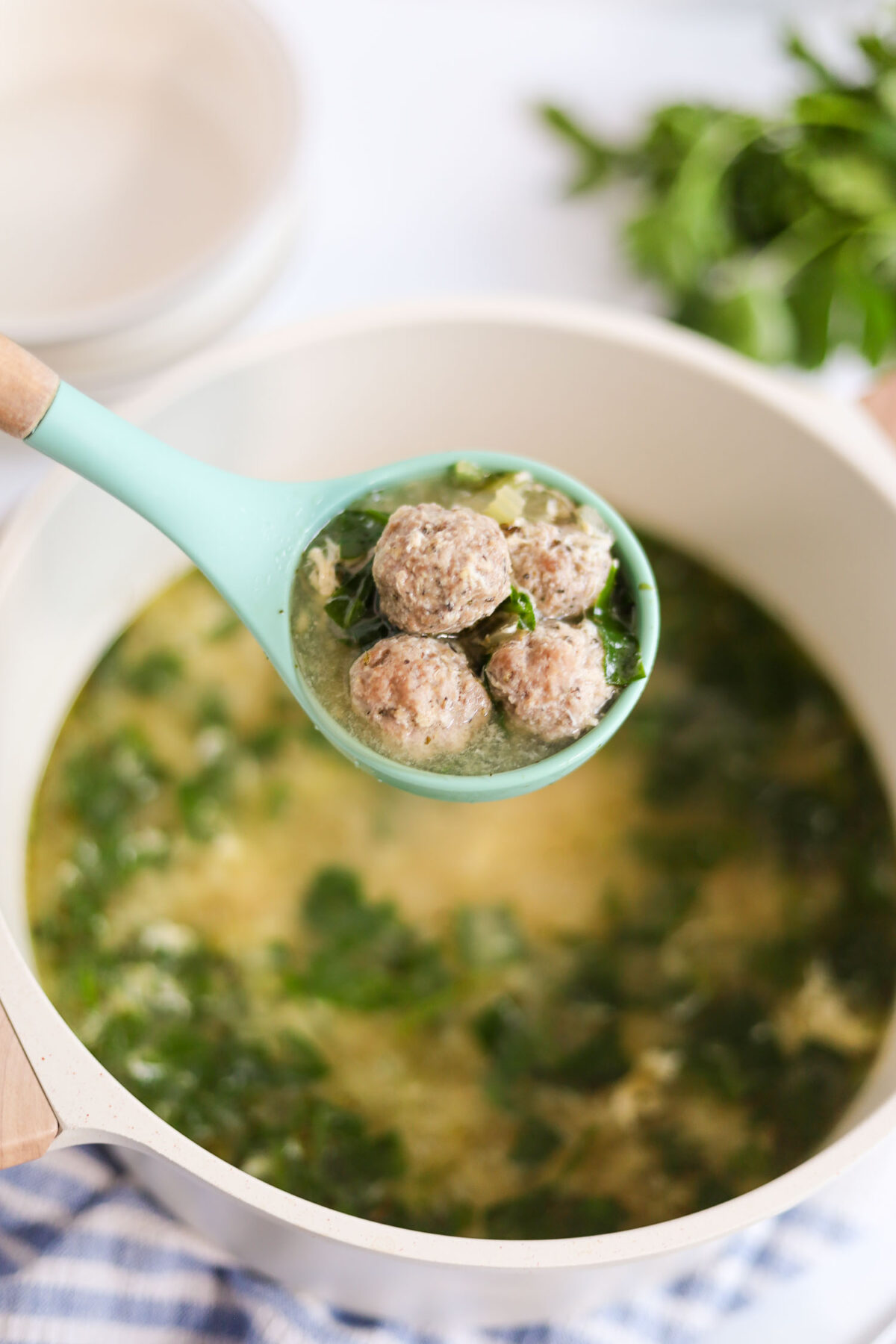 adding grated parmesan cheese to melt into the Italian wedding soup