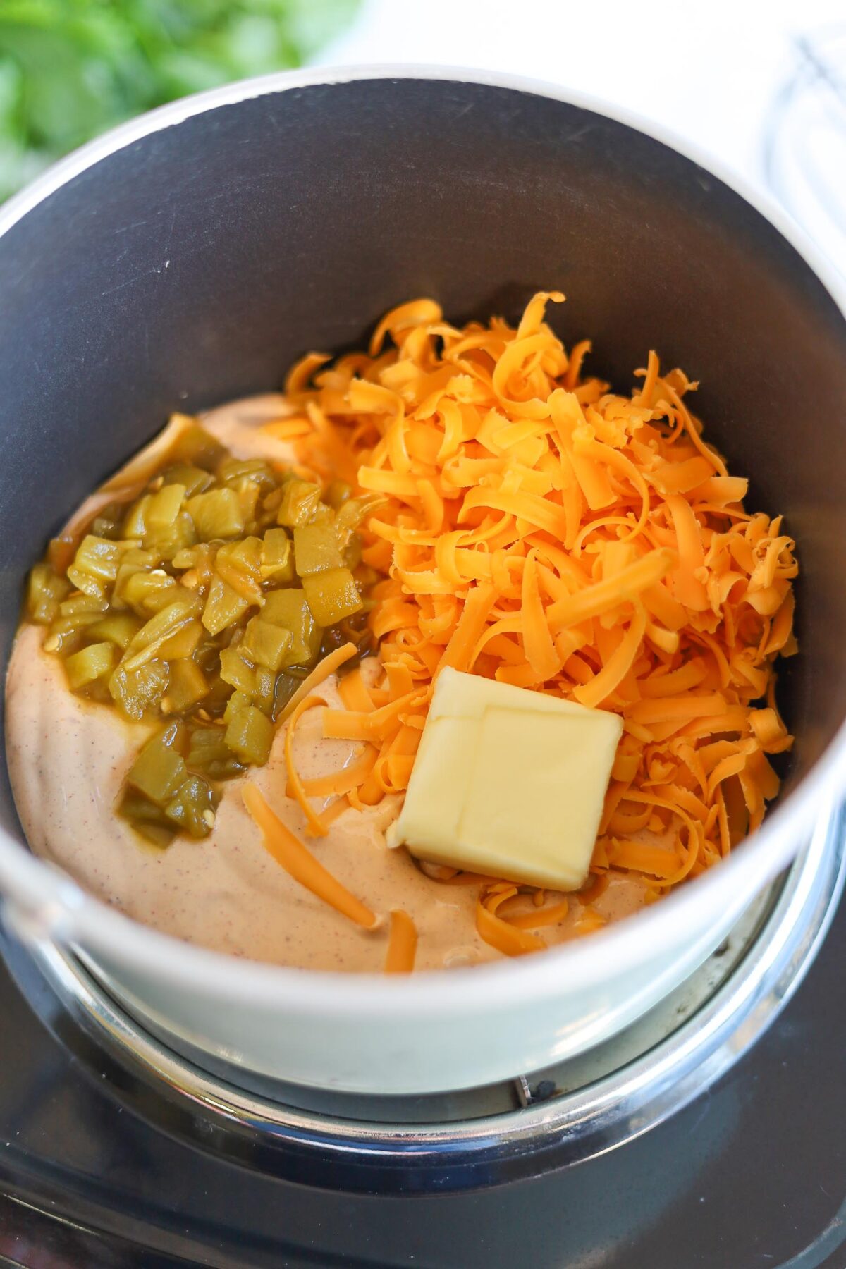 melting shredded cheese, chilis, butter and blended cottage cheese in a pot.