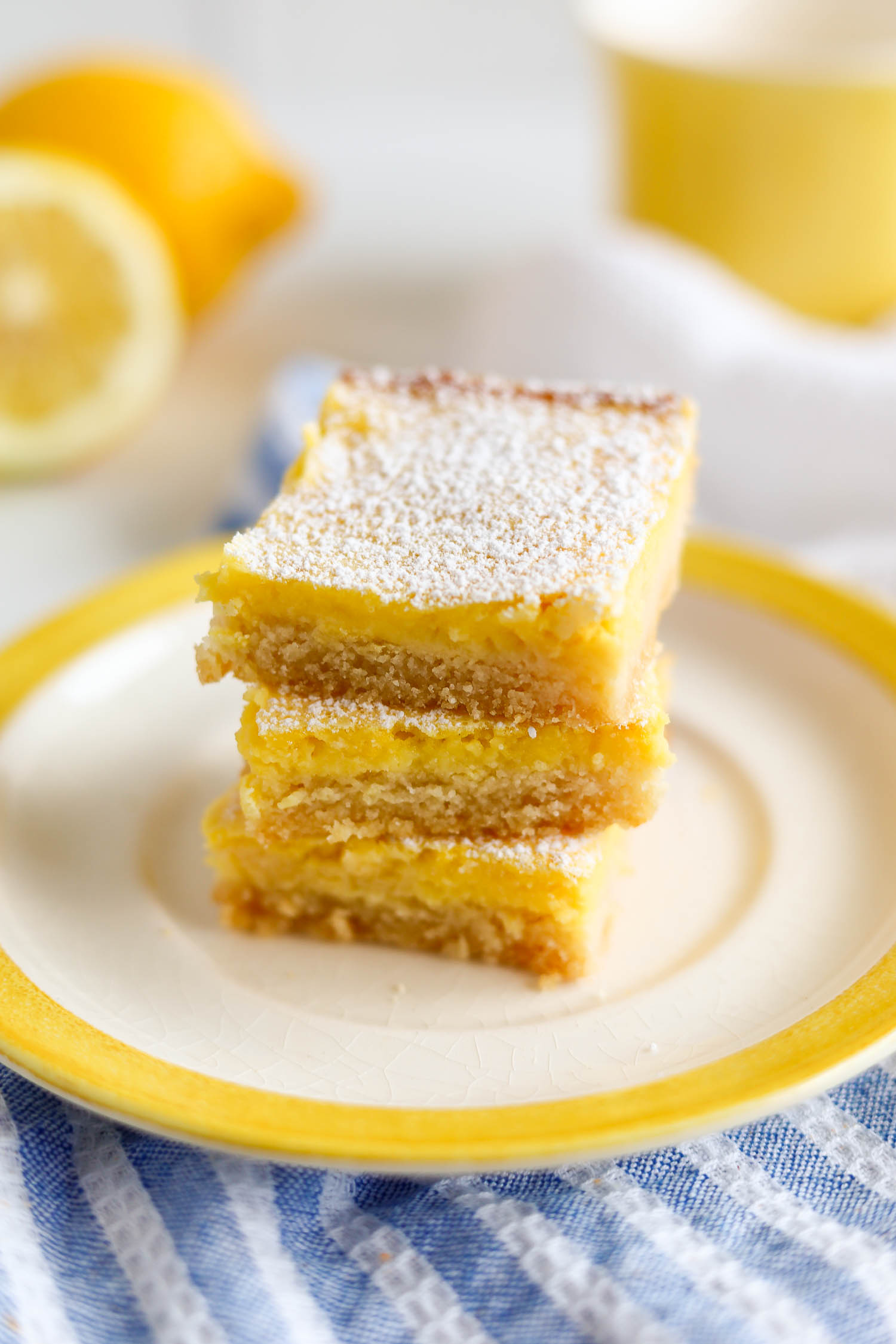 sliced lemon squares stacked on a yellow plate